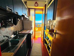 a kitchen with a sink and a door to a balcony at Suite Euforbia Bilo - Sanremo in Sanremo