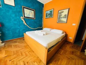 a bedroom with a bed with an orange and blue wall at Suite Euforbia Bilo - Sanremo in Sanremo