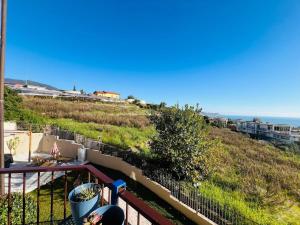 a balcony with a view of a hill and the ocean at Suite Euforbia Bilo - Sanremo in Sanremo