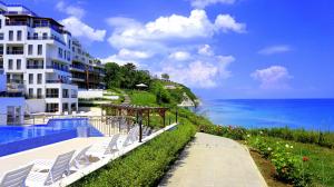 un hotel con piscina junto al océano en Апартаменти Бяла Клиф - Byala Cliff Apartments, en Byala