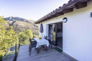 eine Terrasse mit Tisch und Stühlen auf einem Balkon in der Unterkunft Apartamentos rurales La Teyeruca II in Posada de Llanes