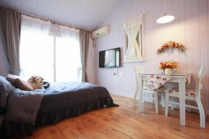 a bedroom with a bed and a desk and a table at Pyeongchang Edelweiss Pension in Pyeongchang