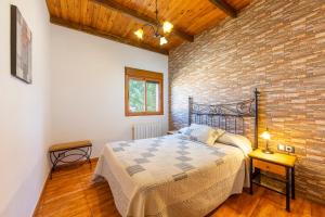 a bedroom with a bed and a brick wall at Casa Rural La Jirola - El Mirador in Escúllar +29 photos