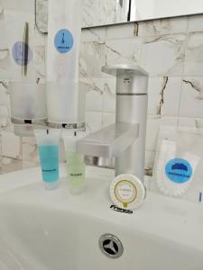 a bathroom sink with a water dispenser and cups at RAX Apartment2 in Morogoro +18 photos