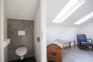a bathroom with a toilet and a blue chair at Vakantievilla | 8 personen in Rhenen +10 photos