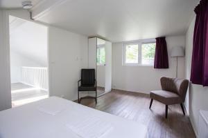 a bedroom with a bed and a chair and a window at Vakantievilla | 8 personen in Rhenen