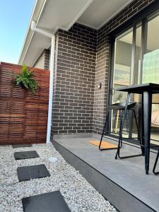 a table on a patio with a brick wall at Modern Ensuite with Private Side Entry in Annangrove +2 photos