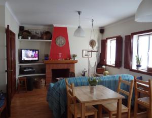 a living room with a table and a fireplace at CASAZUL Milfontes in Vila Nova de Milfontes