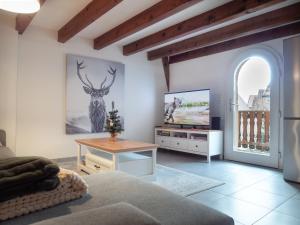 a living room with a bed and a tv at Résidence de 80 m2 avec balcon & cour alsacienne - début Route des Vins in Marlenheim