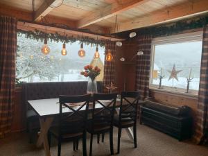 a dining room with a table and chairs and a window at Nordgården in Handeland