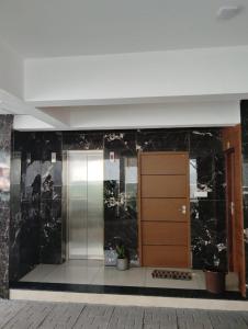an elevator in a building with black marble walls at Grand UNX in Kannur +15 photos