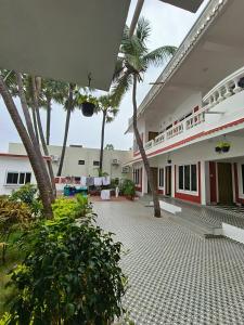 une cour vide d'un bâtiment avec des palmiers dans l'établissement Paradise Sea Wave Resort, à Pondichéry