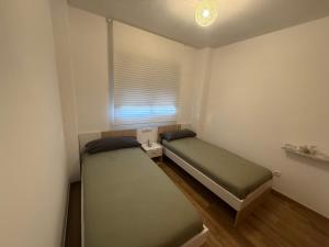 two beds in a small room with a window at Vista Golf in Chiva