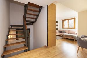 una scala a chiocciola in un soggiorno con divano di Casa Vity by BeValle a Panticosa Altre 30 foto