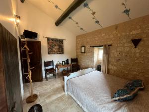 una camera da letto con un letto in una stanza con un muro di pietra di Le Relais des Chevaliers "La Chambre des Templiers" a Cordes-sur-Ciel Altre 28 foto