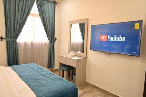una camera d'albergo con TV a parete di ان هاوس ون a Al Khobar