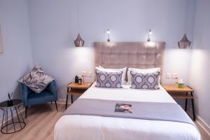 a bedroom with a large bed and a blue chair at LA RÉVERIE in Franschhoek +91 photos