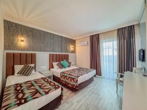 Postel nebo postele na pokoji v ubytování Concordia Celes Beach Hotel