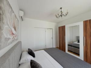 una camera da letto con un letto e un lampadario di Stone & Sun Retreat with Private Pool a Rupalj Altre 37 foto