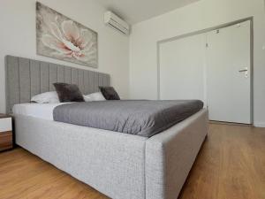 una camera da letto con un letto grande con una grande testiera di Stone & Sun Retreat with Private Pool a Rupalj