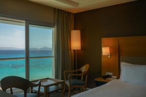 a hotel room with a bed and a view of the ocean at Boyalik Beach Hotel & Spa Cesme in Çeşme