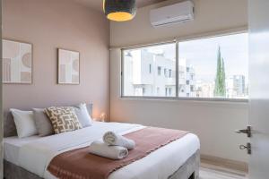 a bedroom with a large bed with a window at Dune - 1 Bedroom Retreat W Balcony in Mackenzie in Larnaka