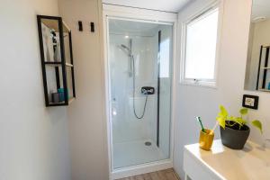 a bathroom with a shower with a glass door at Camping 4 étoiles - Parc aquatique - ef0bdc in Martigues +19 photos