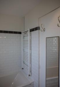 a white bathroom with a tub and a shower at Rameau in Hossegor