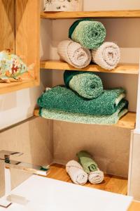 Ein Haufen Handtücher liegt auf einem Regal in der Unterkunft Alt Monjoie in Roetgen + 31 Fotos