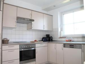 a kitchen with white cabinets and a stove top oven at Dorow Ferienwohnung in Redewisch
