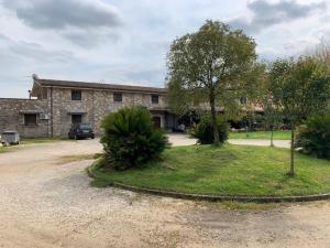 a stone building with a tree in front of it at Le Stanze del Casale Morolo in Morolo