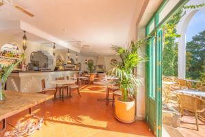 a restaurant with tables and chairs on a patio at Hurricane Beach Hotel in Tarifa