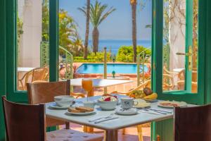 a table with food and a view of a pool at Hurricane Beach Hotel in Tarifa