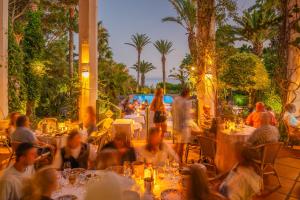 a group of people sitting at tables in a restaurant at Hurricane Beach Hotel in Tarifa