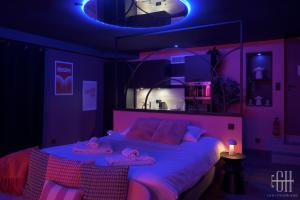 ein lila Schlafzimmer mit einem Bett mit zwei Handtüchern darauf in der Unterkunft La Favorite - Love-Room Sensuelle in Amboise