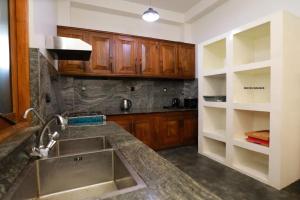 Florain Otium Talpe - 3 Bedroom Oceanfront Villa في يوناواتونا: مطبخ مع حوض ودواليب خشبية