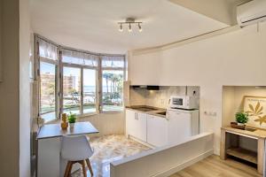 a kitchen with white cabinets and a table with a chair at Mediterranean Way - Promar 248 in La Pineda