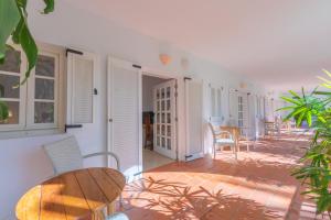 a patio with a wooden table and chairs in a room at Hurricane Beach Hotel in Tarifa