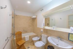 a bathroom with a sink and a toilet and a tub at Hurricane Beach Hotel in Tarifa