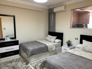 Un dormitorio con dos camas y un espejo. en Hi Pyramids, en El Cairo
