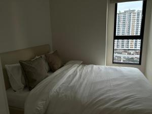 เตียงในห้องที่ Entire apartment near train station with pool & views