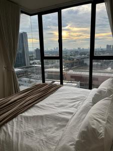 เตียงในห้องที่ Entire apartment near train station with pool & views