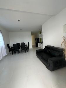 a living room with a black couch and black chairs at Apartamentos Altos de Guayabal in El Triunfo +5 photos