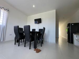 a dining room with a black table and black chairs at Apartamentos Altos de Guayabal in Coveñas +5 photos
