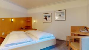 a bedroom with a white bed and a table at Haus Bergkristall in Sankt Anton am Arlberg +63 photos