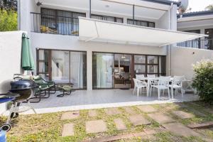 a house with a patio with a table and chairs at Unit 4 Springvale in Zinkwazi Beach