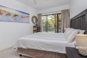 a bedroom with a large bed and a window at Unit 4 Springvale in Zinkwazi Beach