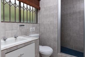 a bathroom with a toilet and a sink and a shower at Unit 4 Springvale in Zinkwazi Beach +16 photos