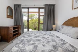 a bedroom with a large bed and a window at Unit 4 Springvale in Zinkwazi Beach