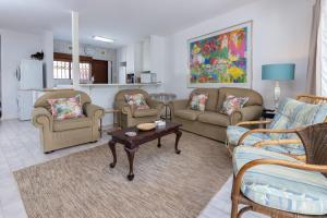 a living room with couches and a table at Unit 4 Springvale in Zinkwazi Beach